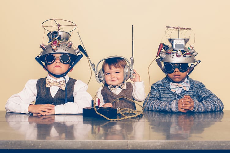 Tres niños con cascos, auriculares y gafas para viajar en el tiempo